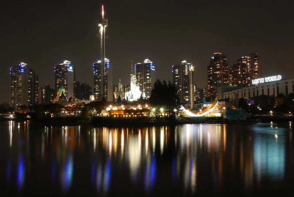 Night view of Lotte World's Magic Island castle and Gyro Drop tower across Seokchon Lake in Seoul. — Photo: travel oriented (CC BY-SA 2.0)