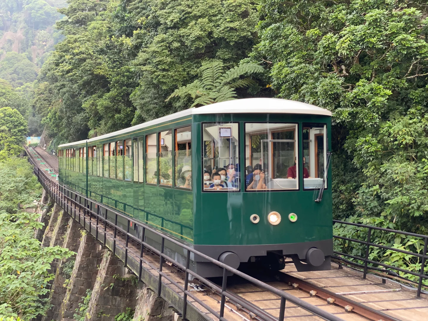 The green sixth-generation Peak Tram climbing the hillside toward Victoria Peak — Photo: LN9267 (CC BY-SA 4.0)